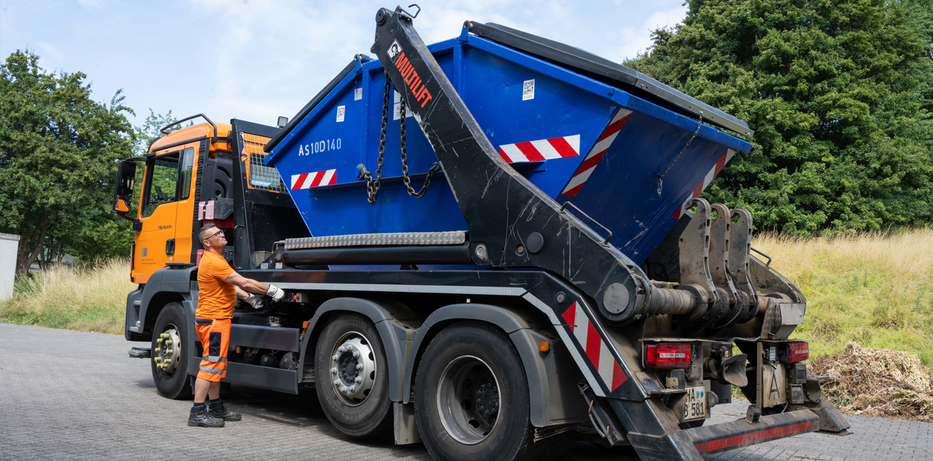 Mitarbeiter der HUI vor einem Absetzkipperfahrzeug